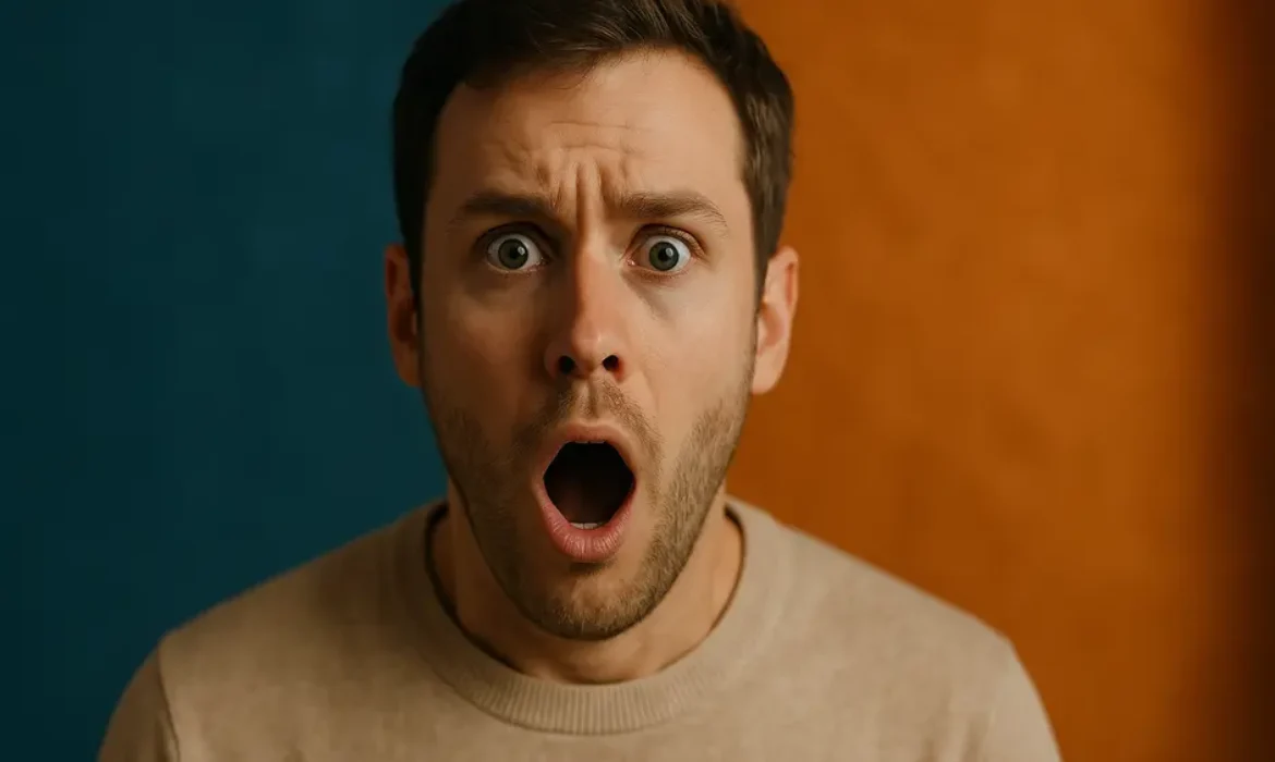 Person with shocked expression off-center against deep blue and bright orange background with bold text